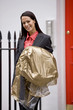 A businesswoman carrying her dry cleaning