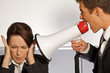 Businesswoman shouting at businessman through megaphone