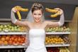 Foto: Smiling bride holding bananas in supermarket Smiling bride holding bananas in supermarket