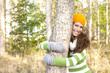 lachend im herbst den baum umarmen