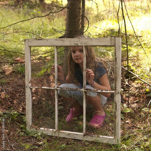 Photo: Young Girl In Woods, Looking Through Old Window Young Girl In Woods, Looking Through Old Window