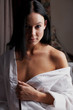 Young brunette woman in her bedroom