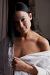 Young brunette woman in her bedroom