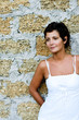 woman in white dress near a brick wall woman in white dress near a brick wall