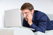 Young man on a couch looking at a computer