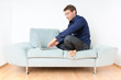 Young man relaxing with laptop on a couch