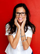 Smiling young woman in glasses against red background Smiling young woman in glasses against red background