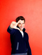 Trendy young guy making a loser gesture with his hand against re