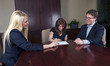happy couple signing documents with advisor