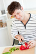 Concentrated young man cutting vegetables in the kitchen