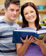 Bright couple of students reading a book Bright couple of students reading a book