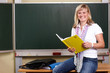 junge Lehrerin mit Klassenbuch