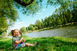 happy girl sitting on river bank happy girl sitting on river bank