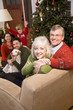 Photo: Senior couple with family by Christmas tree Senior couple with family by Christmas tree