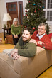 Photo: Mid-adult man and senior parents by Christmas tree Mid-adult man and senior parents by Christmas tree