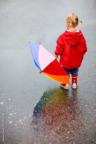 Foto: Toddler girl outdoors at rainy day Toddler girl outdoors at rainy day