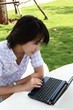 attractive Asian woman is outdoors with laptop attractive Asian woman is outdoors with laptop