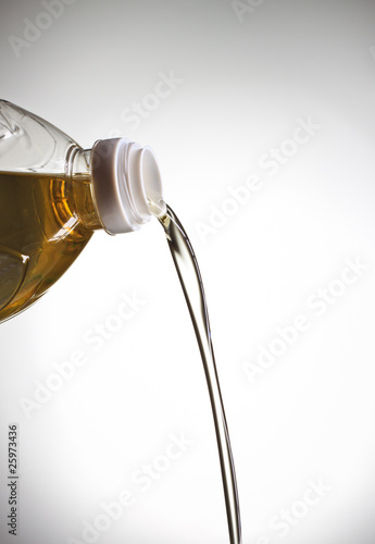 Photo: pouring oil, grey background pouring oil, grey background