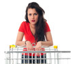 Photo: standing young woman with empty shopping cart standing young woman with empty shopping cart