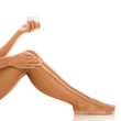 Woman applying cream on legs