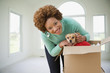 Hispanic woman opening box to find pet dog