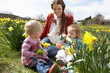 Mother And Daughter In Daffodil Field With Decorated Easter Eggs Mother And Daughter In Daffodil Field With Decorated Easter Eggs