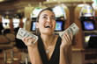 Glamorous mixed race woman in casino holding 100 dollar bills
