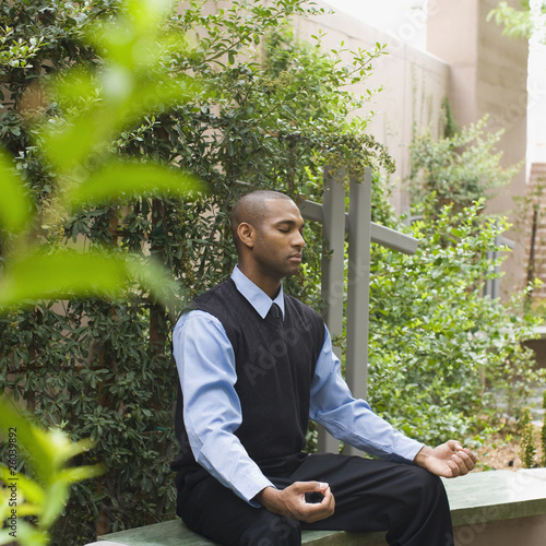 Foto: African businessman meditating in garden African businessman meditating in garden