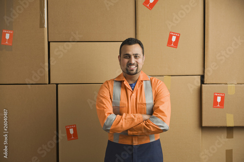 Photo: Indian worker standing near cardboard boxes Indian worker standing near cardboard boxes