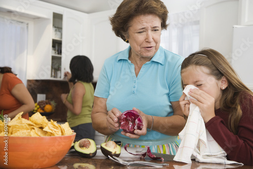 Photo: Hispanic family cooking in kitchen Hispanic family cooking in kitchen