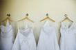 Row of wedding dresses hanging on wall