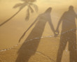 Shadow of couple holding hands at beach