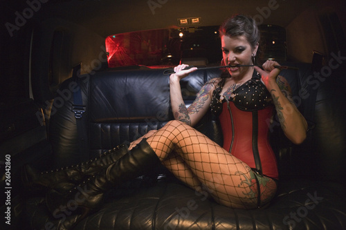 Photo: Dominatrix biting riding crop in limousine Dominatrix biting riding crop in limousine
