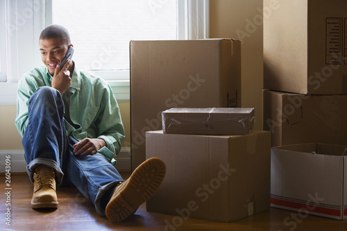 Photo: African man talking on cell phone in new home African man talking on cell phone in new home