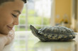 Close up of Hispanic boy smiling at turtle