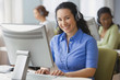 Hispanic businesswoman with headset at desk