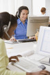 Businesswomen with headsets working at desk