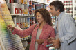 Hispanic couple comparing paint swatches in store