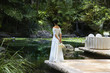 Pacific Islander bride standing at the edge of a pond