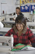 Mixed race woman using sewing machine