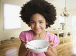 Mixed race girl holding empty cereal bowl