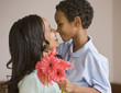 Photo: Mixed race boy giving mother bouquet Mixed race boy giving mother bouquet