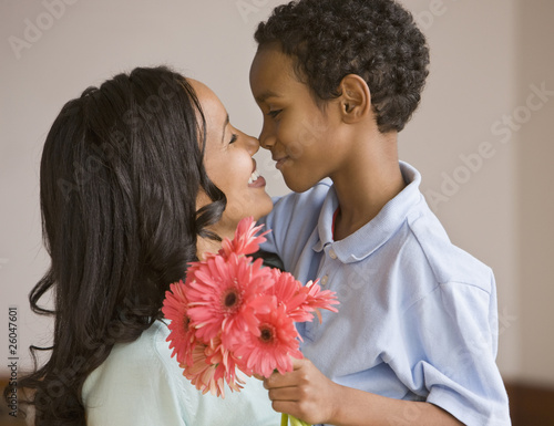 Photo: Mixed race boy giving mother bouquet Mixed race boy giving mother bouquet