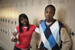 African teenage couple leaning on school lockers
