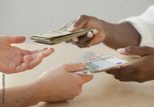 Photo: Woman exchanging Euro notes for US currency Woman exchanging Euro notes for US currency