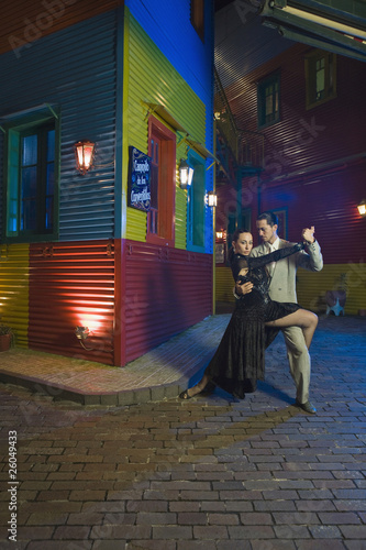 Hispanic couple performing tango on city street
