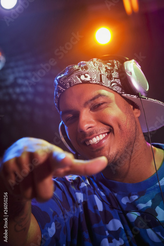 Photo: Hispanic dj in headphones pointing Hispanic dj in headphones pointing