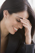 Hispanic businesswoman laughing with head in hands