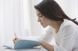 Hispanic woman writing in journal