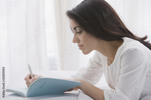 Photo: Hispanic woman writing in journal Hispanic woman writing in journal